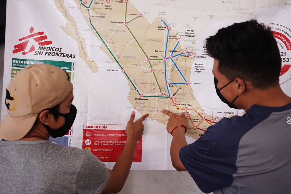 Zwei Männer zeigen auf eine Karte, die Mexio abbildet