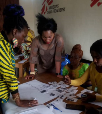 Vier Frauen stehen um einen Tisch herum und planen eine Innovation für die Menstruationshygiene von Frauen