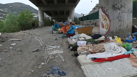 Provisorische Unterkunft aus Betten und Zelten unter einer Brücke