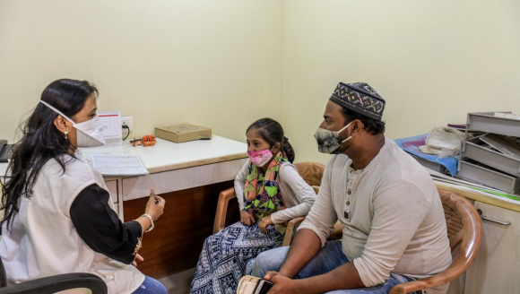 Eine Sozialarbeiterin von Ärzte ohne Grenzen im Gespräch zur Nachsorge mit einer Tuberkulose-Überlebenden und ihrem Vater. 
