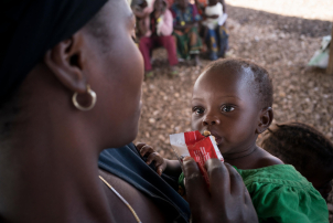 A mother feeds her child a nutricious recovery mixture.