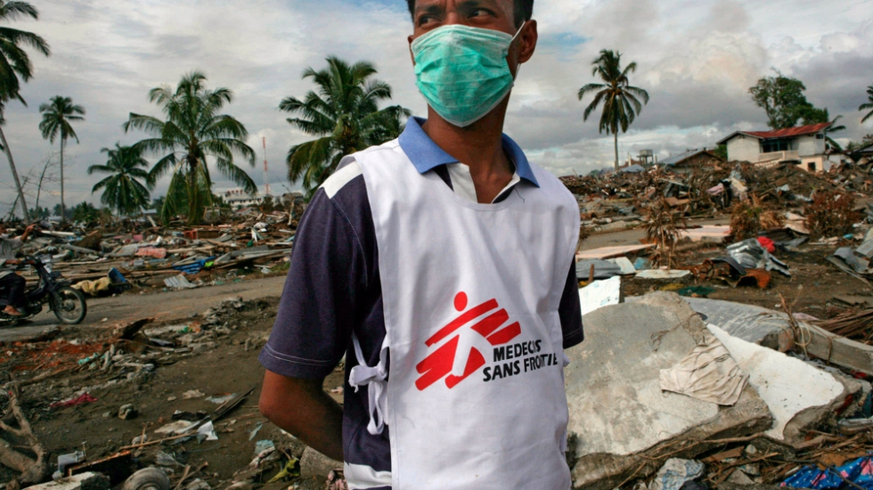 Ein Mann mit Ärzte ohne Grenzen Weste in einem von einem Tsunami zerstörten Gelände in Indonesien