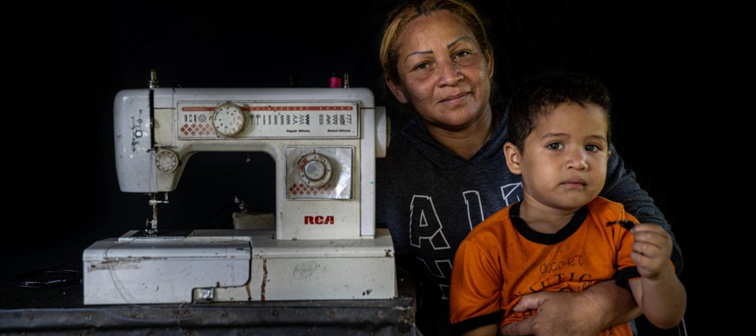 Eine Venezolanerin mit ihrem Sohn und einer Nähmaschine