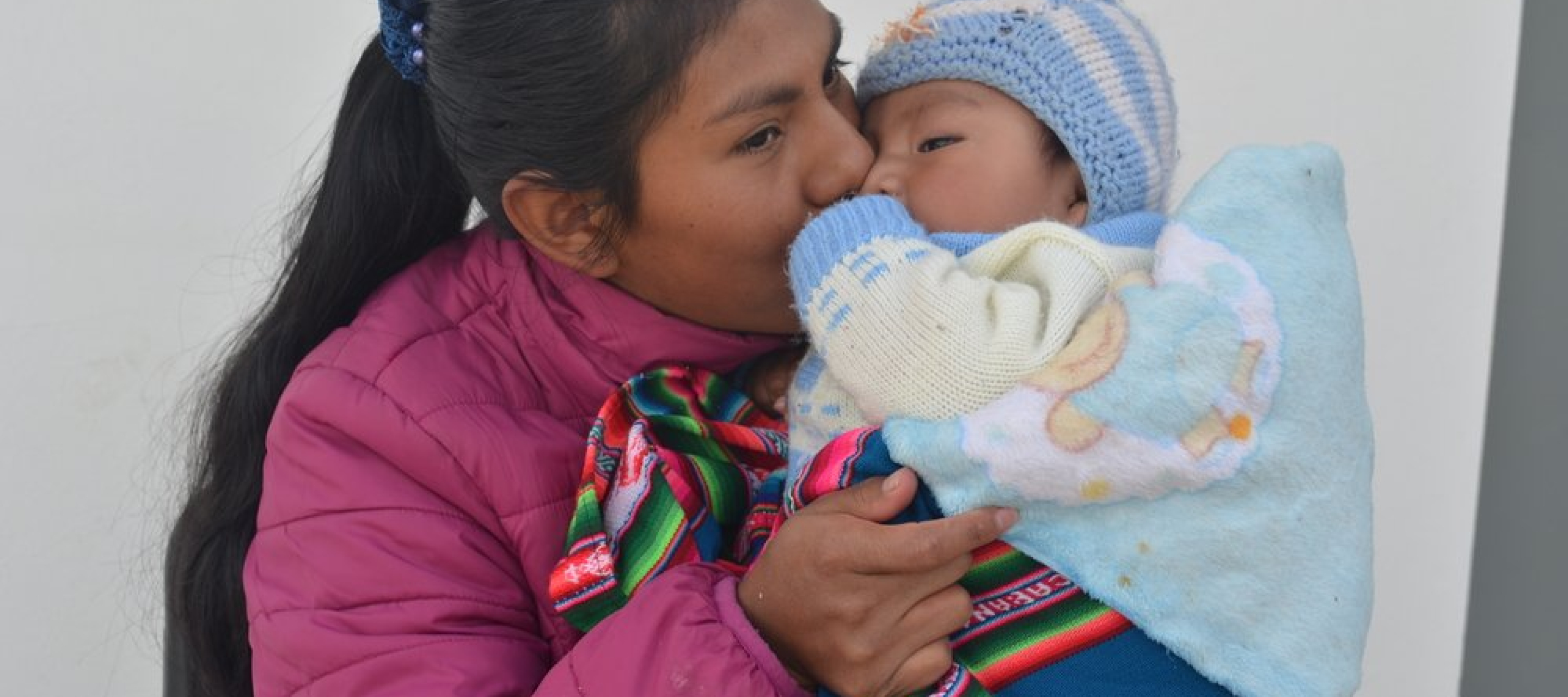 Die Gesundheitsförderin Maribel Camargo Paco küsst ihren 6 Monate alten Sohn
